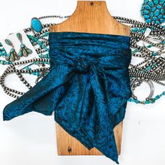 Our beautiful new line of wild rags are so fun and great for the upcoming seasons! Tie this in your hair, around your neck, or around your purse and you're set! Scarf is 100% Silk. Size: Regular Wild rag measures 34.5 x 34.5 inches. SKU: #Baroque-Cobalt (0630-2104) Wild Rags, Giddy Up Glamour, Wild Rag, New Line, Cobalt Blue, Cobalt, One Shoulder Blouse, Purse, Boutique