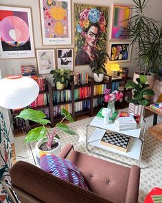 a living room filled with furniture and lots of bookshelves covered in art on the walls