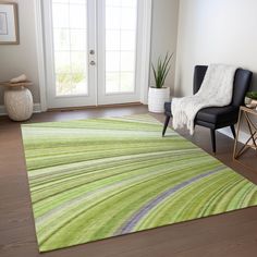 a living room with a chair and rug on the floor in front of a door