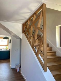 a wooden stair case in a house with white walls and wood flooring on the stairs