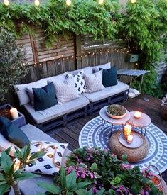 an outdoor living area with couches, tables and lights