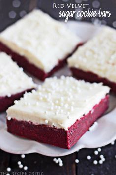 red velvet dessert bars with white frosting on a plate next to sprinkles