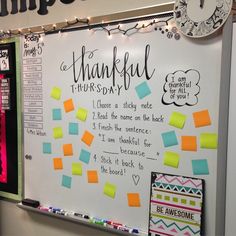 a bulletin board with post it notes attached to it and a clock hanging on the wall