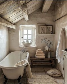 a bathroom with a claw foot tub, sink and window in it's corner