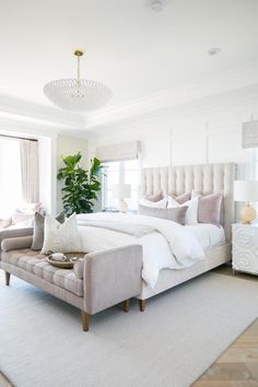 a bedroom with a large bed and white furniture