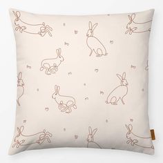 a white pillow with brown rabbits on it