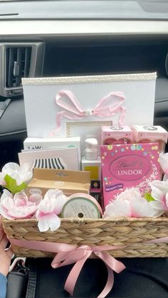 a person holding a basket filled with items in the back seat of a car,