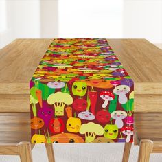 the table is covered with colorfully designed cloths and wooden chairs are in front of it