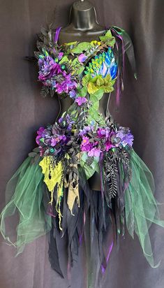 a mannequin made out of flowers and feathers on top of a dress form