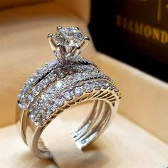 a diamond engagement ring in a box with the wedding band set on top of it