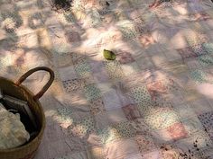 a basket full of clothes sitting on top of a bed next to a tree trunk