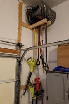 there are many tools hanging on the wall in this garage, including hoses and wrenches