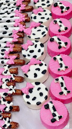 pink and black cupcakes with white frosting on them are arranged in the shape of dogs