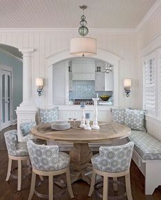 a dining room table surrounded by blue and white chairs