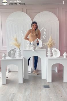 a woman standing in front of some white sculptures