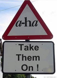 a street sign with the words aha and take them on written underneath it in black letters