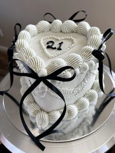 a heart shaped cake with black ribbon on top