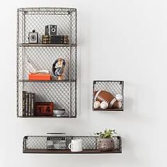 two metal shelving units with books and other items on them in a white room