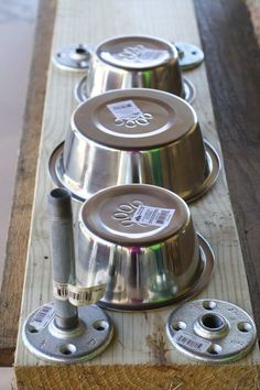 three metal bowls sitting on top of a wooden table