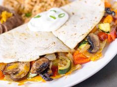 an enchilada is sitting on a plate with rice and other food items