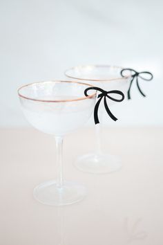 two martini glasses with black bows on them