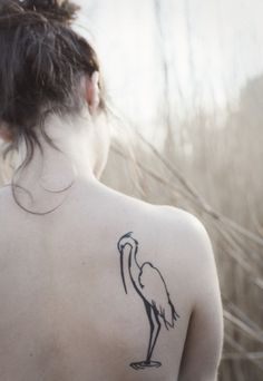 a woman with a bird tattoo on her back