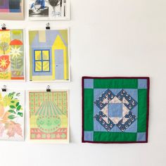 four square paintings hang on the wall next to each other