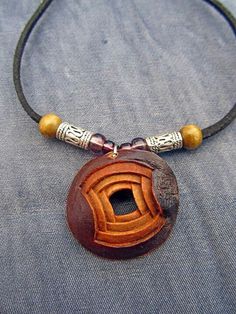 a necklace with a wooden object on it