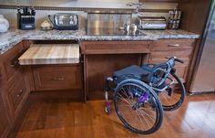 a wheelchair is parked in the middle of a kitchen countertop with stainless steel appliances