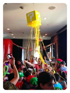 a group of people standing around each other with balloons and streamers in the air