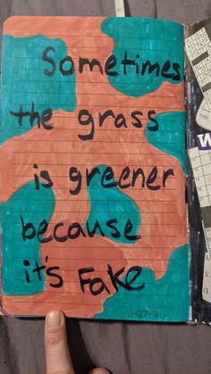 someone is holding up a piece of paper that says sometimes the grass is greener because it's fake