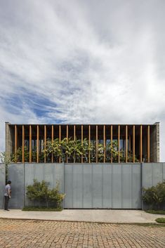 a person standing in front of a building with wooden slats on it's side