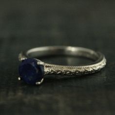 "Lapis Lazuli Ring Full Cut Lapis Ring Blue Engagement Ring Antique Style Ring Sterling Silver Alternative Engagement Ring Blue Jeans Looking for your bride's \"something blue\"? Look no further than our Lapis Lazuli solitaire \"Blue Jeans\" ring. This traditional setting is modernized with a full cut 6mm Lapis Lazuli stone. Its name comes from the Latin lapis, \"stone,\" and the Persian lazhuward, \"blue.\" It is said to help bring inner peace and clear one's mind from negative thought patterns Heirloom Blue Sapphire Promise Ring, Adjustable Blue Sapphire Ring Fine Jewelry, Blue Sterling Silver Round Band Jewelry, Blue Sapphire Rings For Promise, Classic Adjustable Sapphire Promise Ring, Engraved Round Sapphire Jewelry, Royal Blue Round Sapphire Ring, Blue Gemstone Jewelry With Round Band, Sapphire Jewelry With Diamond Cut In Round Band