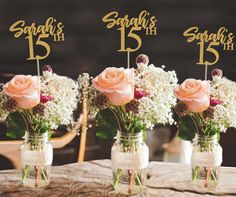 three mason jars filled with flowers sitting on top of a table next to each other