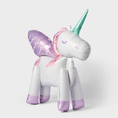 an inflatable unicorn toy sitting on top of a white floor next to a wall