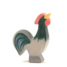 a ceramic rooster figurine sitting on top of a white surface with an orange beak