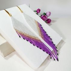 purple and white beaded fringe earrings on display