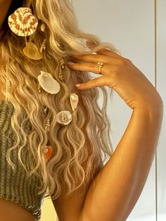 a woman with long blonde hair and seashells on her head