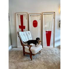 a black and white dog standing on top of a chair in front of two doors