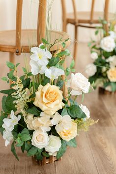 the flowers are arranged in vases on the wooden floor next to each other, along with greenery