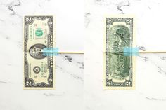 one dollar bill is taped to the wall with a piece of blue tape on it