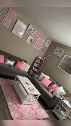 a living room with grey couches and pink pillows on the rugs in front of them