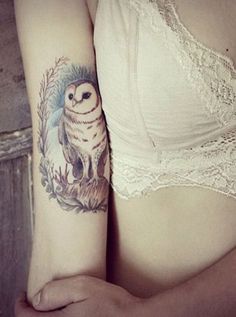 a woman with a owl tattoo on her arm