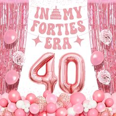 pink balloons and streamers are in front of a backdrop with the number forty on it