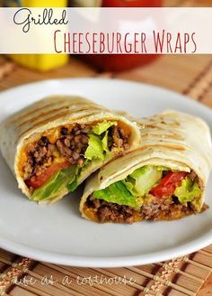 a white plate topped with a burrito cut in half and filled with cheeseburger wraps