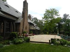 a large brick house with a clock tower in the middle of it's yard