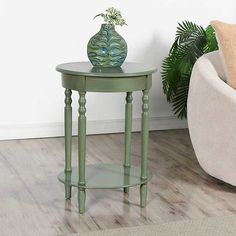 a green vase sitting on top of a small table