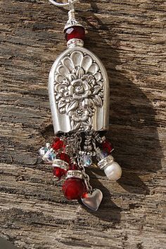 a silver necklace with red beads and charms