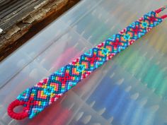 a colorful beaded bracelet sitting on top of a plastic container