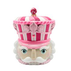 a pink and white toy with a crown on it's head next to a candy container